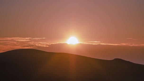 地平線に雲や丘が立ち並ぶピンク色の太陽が昇る タイムラプスビデオ — ストック動画