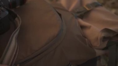 Sırt çantasını tarlada sallayan yürüyüşçünün eli. Diziden görüntüler