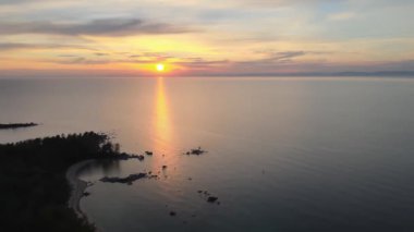 Gün batımında sup sörfçüsüyle deniz manzarası