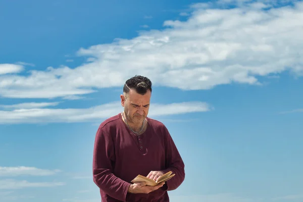 Sahilde kitap okuyan bir adam.