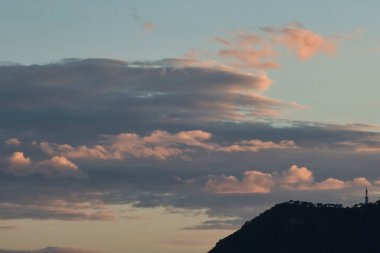 Bir dağın siluetini çerçeveleyen geniş bulutlu manzara