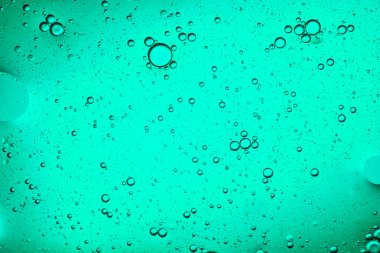 Hareket eden baloncukların açık yeşil sıvı arkaplanının yakın plan görüntüsü