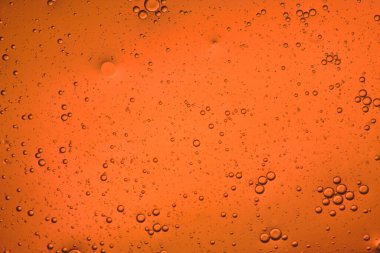 Hareket eden baloncukların parlak turuncu sıvı arkaplanının yakın plan görüntüsü