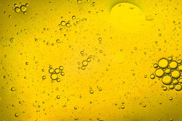 close-up view of a yellow liquid background of moving bubbles