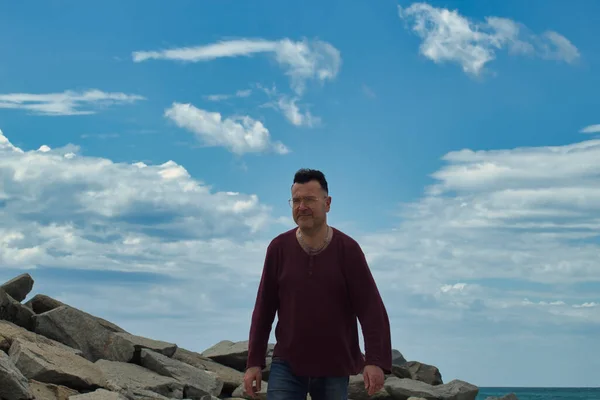 Sahilde yalnız bir adam ön plana çıkıyor.