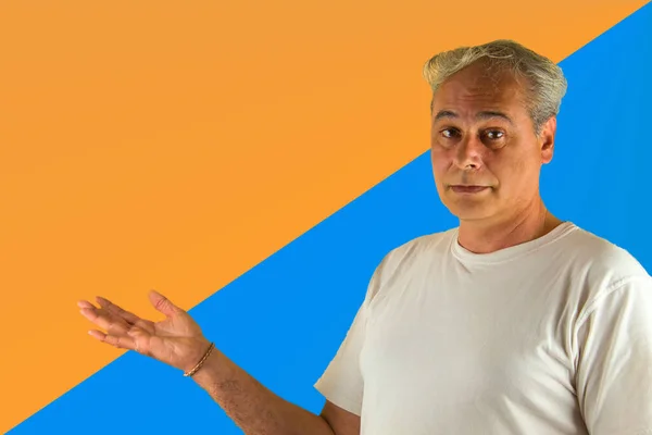Šedovlasý Muž Ukazuje Něco Rukou Modrém Oranžovém Pozadí — Stock fotografie