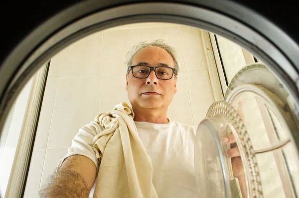 Älterer Mann Holt Kleidung Aus Der Waschmaschine — Stockfoto