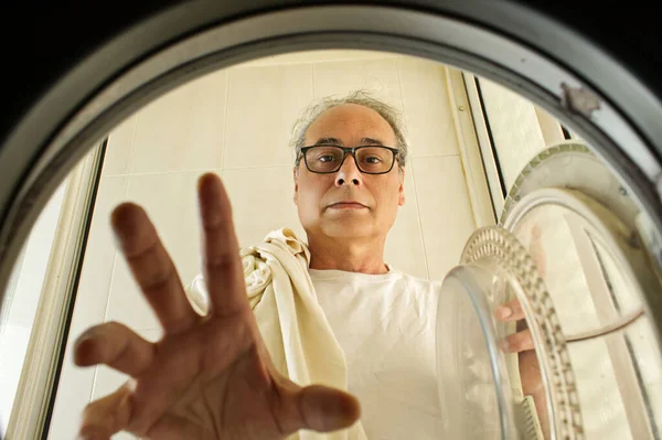 Älterer Mann Holt Kleidung Aus Der Waschmaschine — Stockfoto