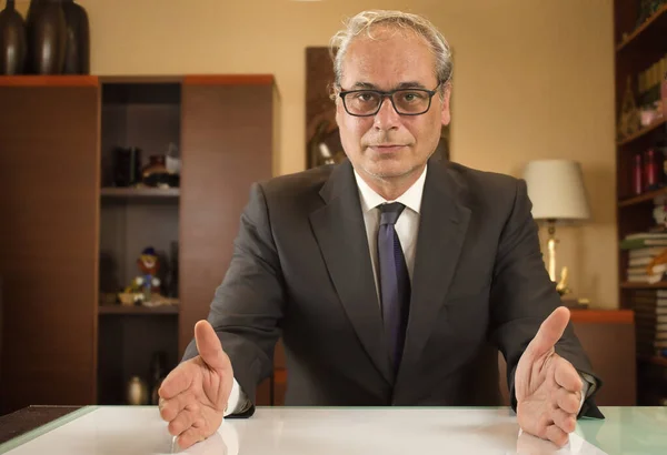 Kolları açık iş adamı kendinden emin bir şekilde önde görünüyor.