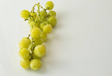 Beyaz arkaplanda damlaları olan bir grup üzümün önplanı