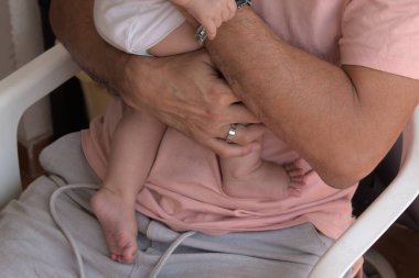 Bir adamın bebeğini dikkatle tutmasının ön planı