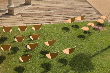 Çimenlikteki ayrı sandalyeler. Kısıtlı bir tören için hazır.