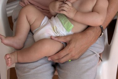 Babamın bebeğini kucağında tutarken ön planı.