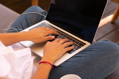  Elleri bilgisayar ve kahve tutan bir kadın.