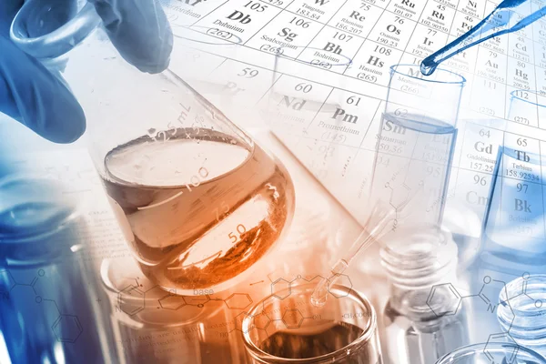 Artículos de vidrio de laboratorio, tubos de ensayo y frascos en laboratorio con ecuaciones químicas y fondo de tabla periódica . — Foto de Stock