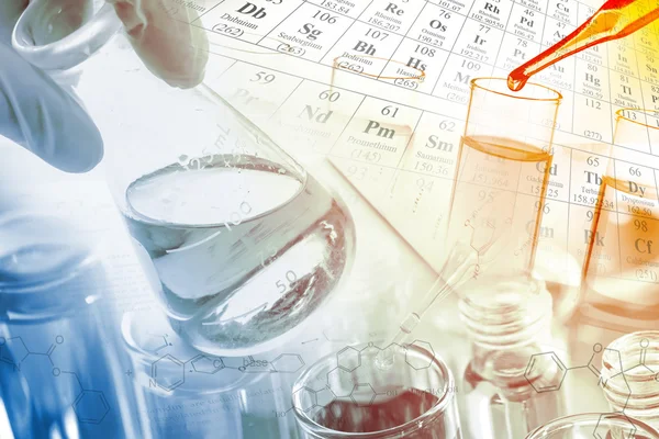 Artículos de vidrio de laboratorio, tubos de ensayo y frascos en laboratorio con ecuaciones químicas y fondo de tabla periódica . — Foto de Stock
