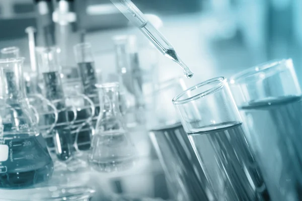 Een onderzoeker laten vallen van het duidelijke reagens in de reageerbuis voor reactie testen met chemisch laboratorium. — Stockfoto