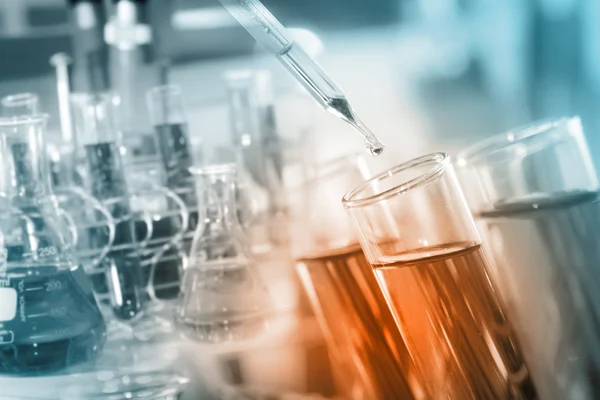 Açık reaktif reaksiyon kimyasal laboratuvar testleri için test tüp içine bırakarak bir araştırmacı.