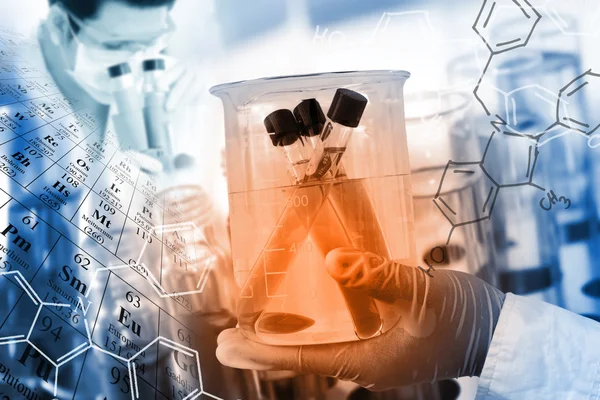 Concepto científico, mano enguantada sostenga un vaso de precipitados en sala de laboratorio con tabla periódica y fondo de estructura química — Foto de Stock