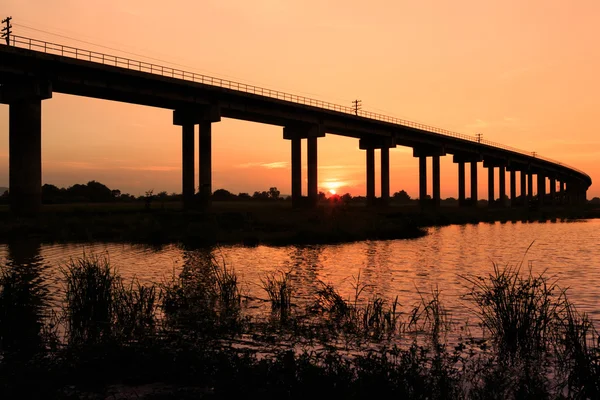 Τρένο γέφυρα πάνω από το φράγμα στο ηλιοβασίλεμα στην Ταϊλάνδη Royalty Free Φωτογραφίες Αρχείου
