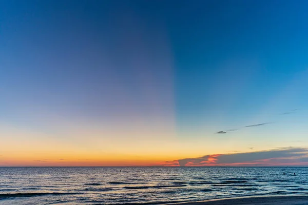 Tramonto sulla spiaggia guardando l'orizzonte sull'acqua contro il cielo epico — Foto Stock