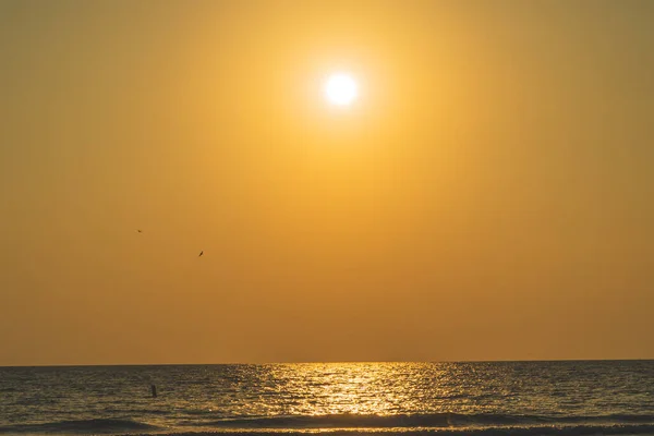 Vista panoramica del Sole in cielo arancione che riflette sull'acqua durante il tramonto — Foto Stock