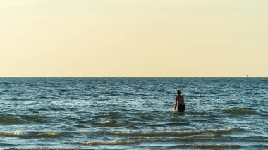 Gençlik berrak gökyüzüne karşı mavi sularda süzülüyor