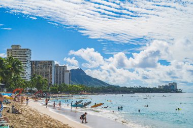 Oahu Hawaii halkı, arka planda Diamond Head ile Waikiki plajında eğleniyor.