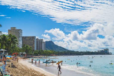 Oahu Hawaii halkı, arka planda Diamond Head ile Waikiki plajında eğleniyor.