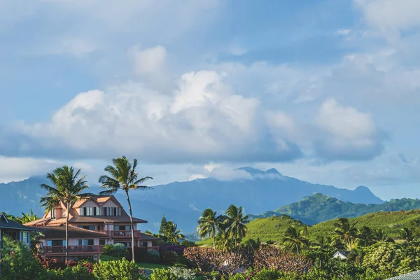Hus sitter på kullen omgiven av palmer på tropisk ö mot berg — Stockfoto
