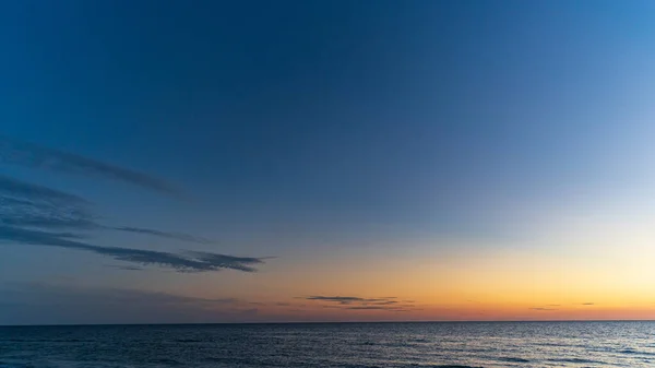 Tramonto sulla spiaggia guardando l'orizzonte sull'acqua contro il cielo epico — Foto Stock