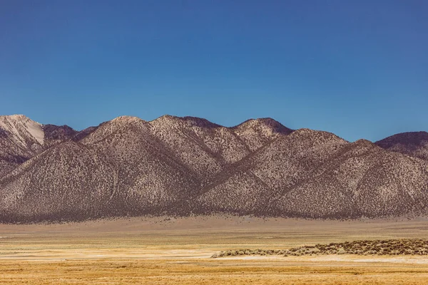 Planícies áridas contra a Serra Nevada Montanhas e céu azul com nuvens — Fotografia de Stock