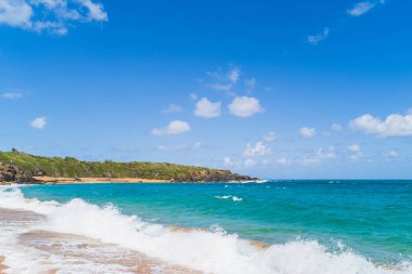Tropikal Kızıl Kum Sahili 'nin panoramik manzarası ve gökyüzüne karşı mavi su