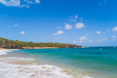 Tropikal Kızıl Kum Sahili 'nin panoramik manzarası ve gökyüzüne karşı mavi su