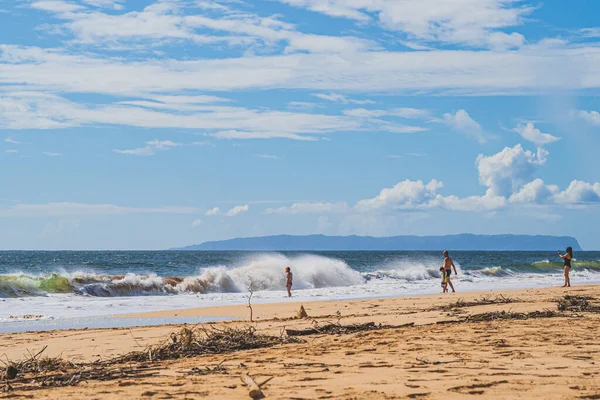 Los turistas juegan en la gran oleada que se estrella del océano Pacífico en Hawai — Foto de Stock
