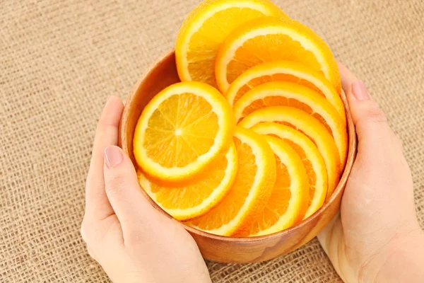 Fruit in een houten kom en mand, haar handen holdson schepen — Stockfoto