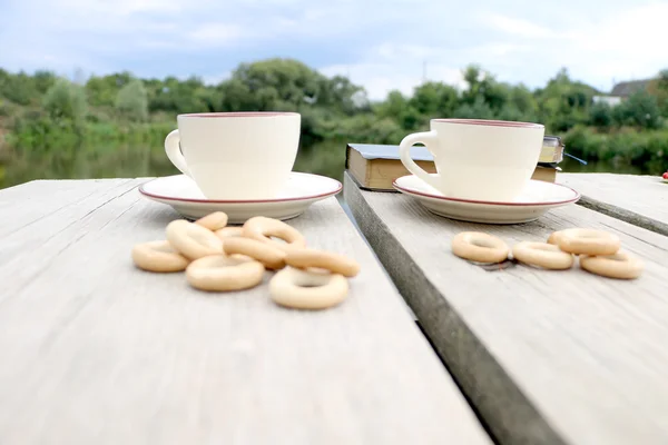 Dos Tazas Café Bagels Sobre Mesa Junto Lago —  Fotos de Stock