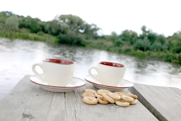 Dos Tazas Café Bagels Sobre Mesa Junto Lago —  Fotos de Stock