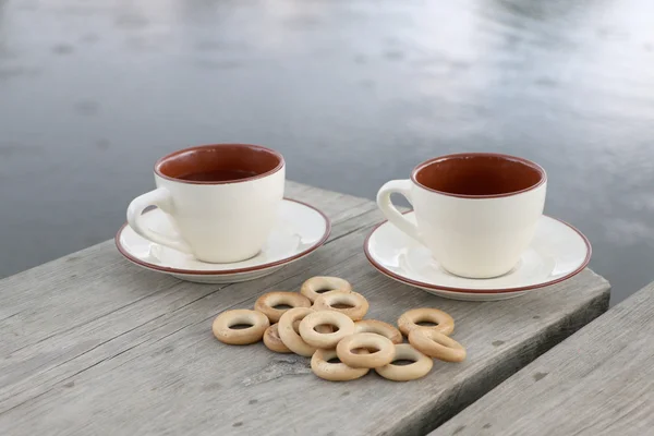 Dos Tazas Café Bagels Sobre Mesa Junto Lago —  Fotos de Stock