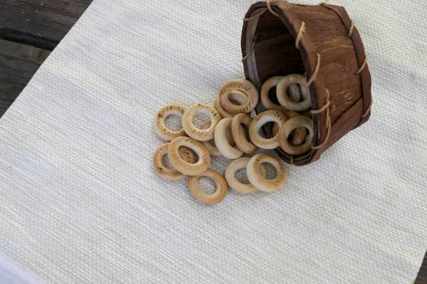 Rosquillas en una canasta con platos vacíos sobre la mesa —  Fotos de Stock
