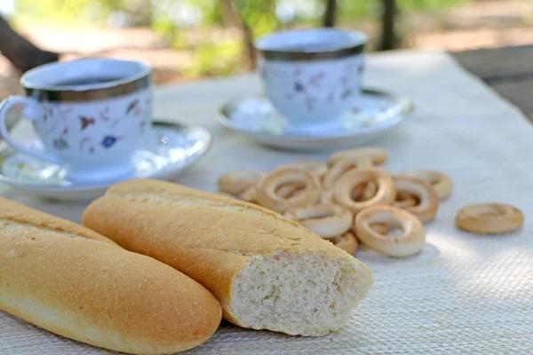 Κατακόκκινη καρβέλι στο τραπέζι και στενή bagels και φλιτζάνι καφέ — Φωτογραφία Αρχείου