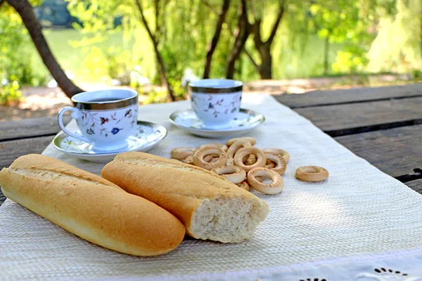 Ruddy pan en la mesa y cerrar los bagels y la taza de café —  Fotos de Stock