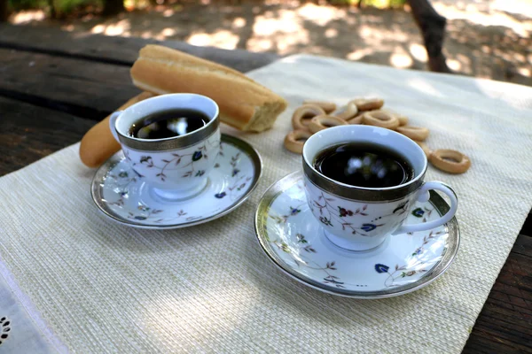 Ruddy pan en la mesa y cerrar los bagels y la taza de café —  Fotos de Stock