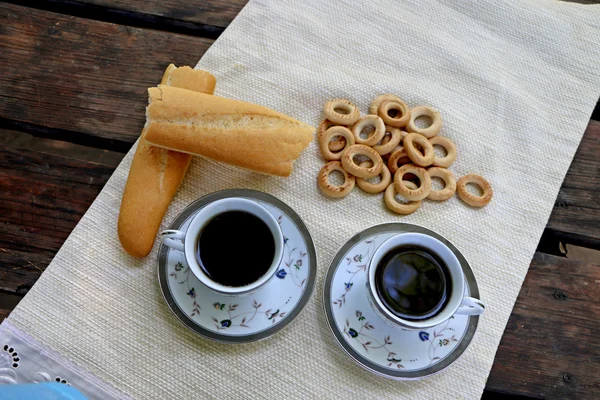 Ruddy pan en la mesa y cerrar los bagels y la taza de café —  Fotos de Stock