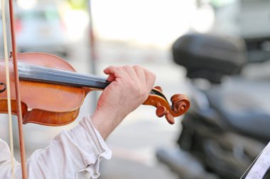 Adam sokakta keman çalıyor.