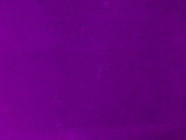 Arka plan olarak kullanılan mor kadife kumaş dokusu. Yumuşak ve pürüzsüz tekstil malzemelerinin boş mor kumaş arkaplanı. Metin için boşluk var.