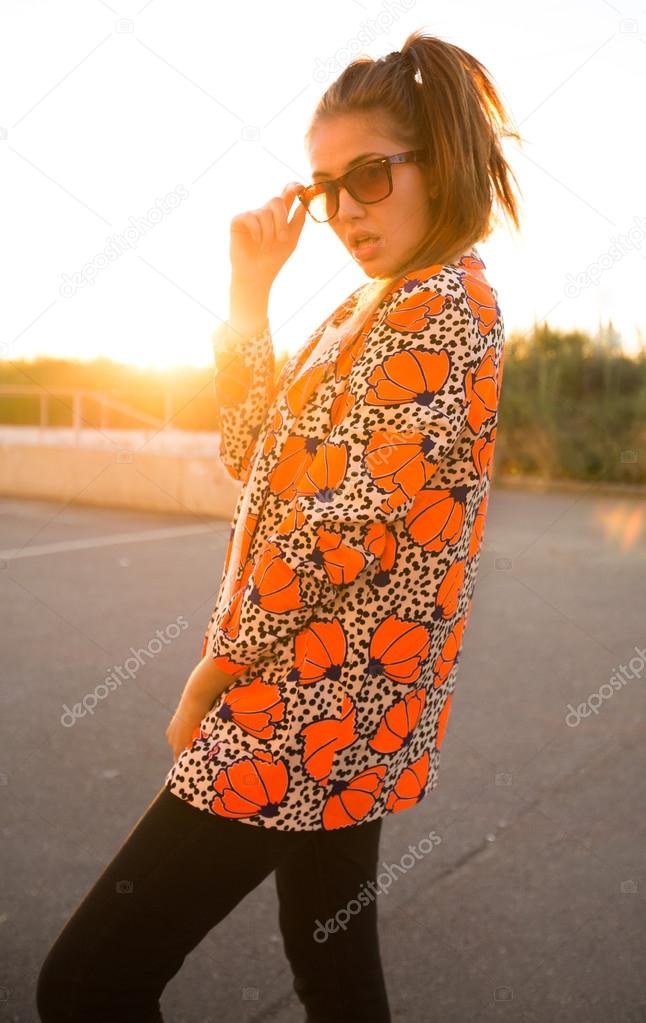 young stylish woman posing at sunset