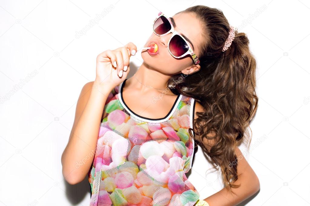 Beauty fashion girl eating lollipop.