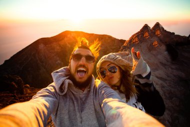 Beautiful traveling couple on the top of the mountain clipart