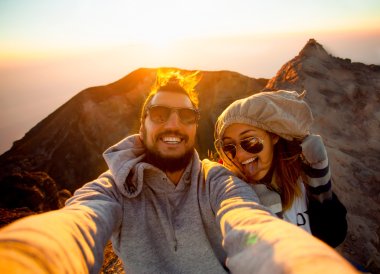Beautiful traveling couple on the top of the mountain clipart